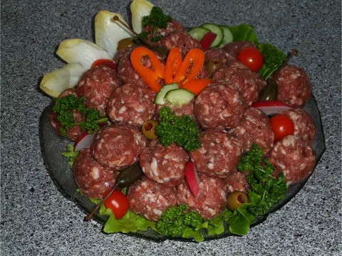 Geformter Hackepeter mit Zwiebeln und Garnitur